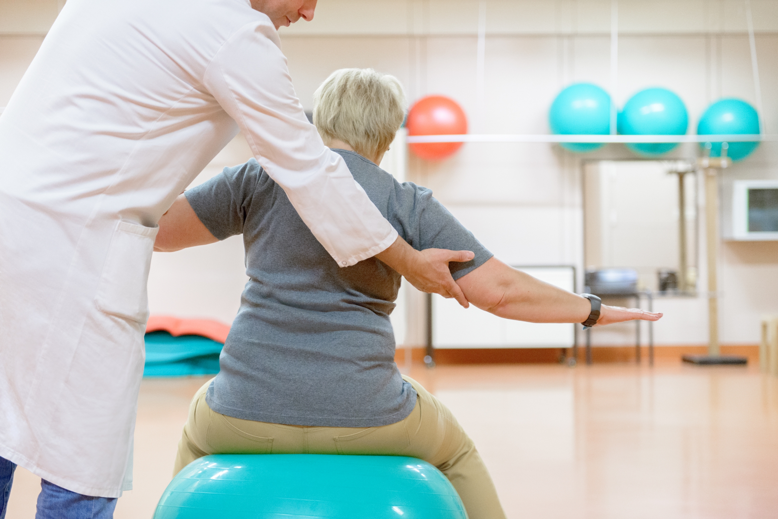 Patientin in der Phsyikalischen Medizin am Pezziball